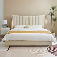 a bedroom with a bed, nightstand and potted plant on the floor in front of it