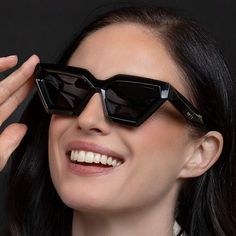 a woman wearing black sunglasses and smiling