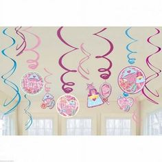 some pink and blue streamers hanging from the ceiling in a room with white walls