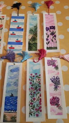 the bookmarks are decorated with flowers and birds on them, along with tassels