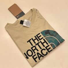 Wear The North Face Men's Half Dome T-Shirt To Show Your Style. Made Of 100% Recycled And Sustainable Cotton For Comfort, This Shirt Comes With A Screen-Printed Logo Graphic On The Chest For A Touch Of Style. Features And Benefits Made Of 100% Recycled And Sustainable Cotton For Comfort Short, Set-In Sleeves Ribbed Crew Neck Screen-Printed Graphic On The Chest Adds Style Standard Fit Circular Design Allows The Shirt To Be Recycled At The End Of Its Life Casual The North Face Tops For Outdoor, Casual Outdoor Tops By The North Face, The North Face Cotton Graphic T-shirt, The North Face Relaxed Fit Cotton T-shirt, Casual Relaxed Fit T-shirt By The North Face, Face Tan, North Face Shirts, North Face Shorts, Tan Face