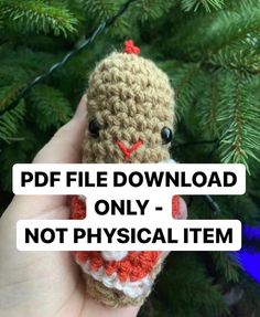 a hand holding a small crocheted stuffed animal in front of a christmas tree