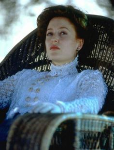 a woman sitting in a wicker chair with her head turned to the side and eyes closed