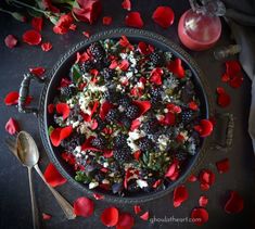 a bowl filled with blackberries, raspberries and other food on top of a table