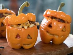 three carved pumpkins sitting on top of a wooden table