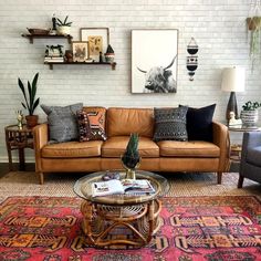 a living room filled with lots of furniture next to a white brick wall and potted plants