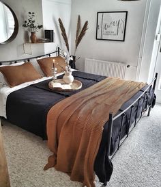 a bedroom with a bed, mirror and other items on the table in front of it