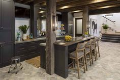 a kitchen with an island, bar and stools next to it in the center of the room