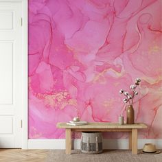 a pink and gold wallpaper in a living room with a wooden table on the floor