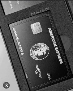 a black and white photo of an american express credit card sloted into a machine