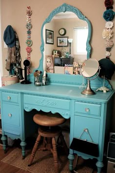 a desk with a mirror, stool and other items on top of it in a room