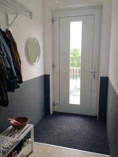 an entryway with clothes hanging on the wall