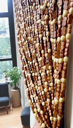 a large piece of art made out of wooden beads and wood planks is hanging on the wall