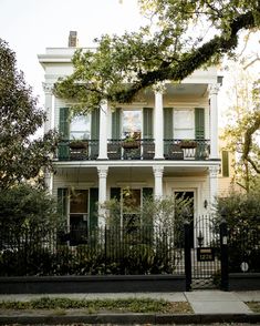 a large white house with green shutters and balconies