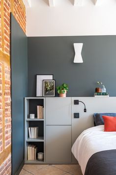 a bed sitting next to a book shelf in a bedroom