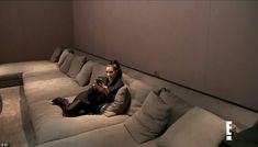 a woman sitting on top of a gray couch