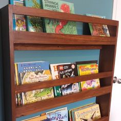 the bookshelf is full of children's books and has three shelves on each side