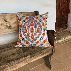 a wooden bench with a decorative pillow on it