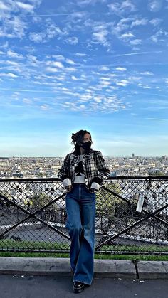 a woman standing on top of a metal fence