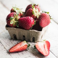 some strawberries are sitting in a container on the table