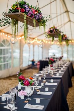 an image of a table set up with flowers and greenery hanging from the ceiling