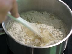 a person mixing food in a pot on the stove