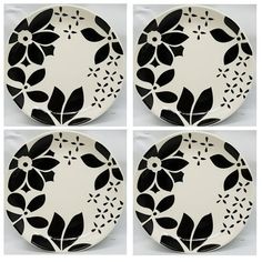 four black and white plates with flower designs on the sides, all in different shapes