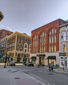 people are walking down the street in front of some buildings