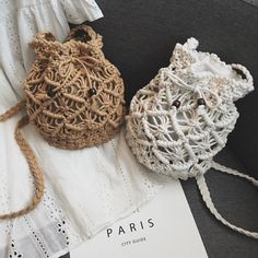 two crocheted bags sitting on top of a white piece of paper next to each other