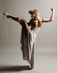 a woman in a white dress is doing a dance move with her legs spread out