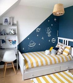 a child's bedroom decorated in blue and white with space themed wall decals