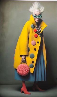 a woman in yellow coat and blue dress holding a pink ball with polka dots on it