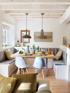 a living room filled with furniture next to a kitchen and dining room table in front of a window