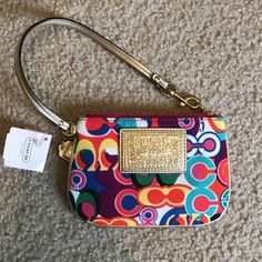 Coach Pop C Multi Color Signature Wrislet Wallet F48151 Special Features: Bright Gold Lurex/Metallic Leather Piping, Trim & Wrist Strap. Strap Measures 14" From End To End With A Brass Dog Leash / Spring Clip At One End. The Multi-Color Poppy Pop C Signature Denier Nylon Fabric Is Beautiful! Coach & Poppy Embossed Rectangular Logo Sewn On Front. * Imported From : Usa * Exterior: The Multi-Color Poppy Pop C Signature Denier Nylon Fabric Is Beautiful! Coach & Poppy Embossed Rectangular Logo Sewn Multicolor Coach Bags As Gifts, Trendy Coach Rectangular Clutch, Trendy Rectangular Coach Clutch, Multicolor Coach Clutch Bag, Coach Multicolor Clutch Bag, Coach Multicolor Travel Wristlet, Multicolor Clutch With Cell Phone Pocket, Coach Multicolor Wristlet For Travel, Multicolor Coach Wristlet For Travel