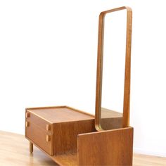 a wooden dresser with a mirror on top of it and two drawers underneath the drawer