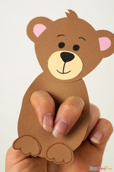 a hand holding up a brown bear cutout