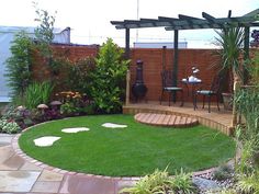 a small backyard with green grass and wooden steps