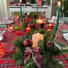 a christmas table setting with candles and decorations