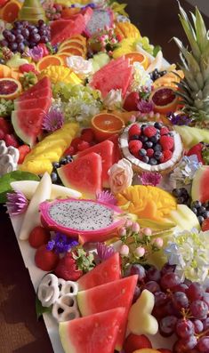 a table topped with lots of cut up fruits and veggies on top of it