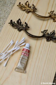 some wood and paint sitting on top of a wooden board next to an ornate handle