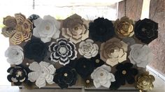 a bunch of paper flowers are hanging on the wall