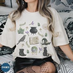 Introducing our Witchy Cottagecore Shirt - the perfect choice to express yourself this spooky season! This witchy aesthetic tshirt features a watercolor witchcraft collage graphic making it the perfect way to show off your unique style. Whether you're looking for a dark cottagecore shirt for yourself or for someone special, you'll find it here. Get ready to show off your love for the witchcore aesthetic with this trendy tee! Comfort Colors introduces its garment-dyed t-shirt made 100% with ring- Witchy Tshirt Design, Halloween Long Sleeve Fairy Grunge Tops, Halloween Fairy Grunge Long Sleeve Tops, Fairy Grunge Long Sleeve Halloween Tops, Fairy Grunge Halloween T-shirt With Crew Neck, Halloween Fairy Grunge T-shirt With Crew Neck, Witchy Short Sleeve Cotton Tops, Witchy Cotton Short Sleeve Tops, Goblincore Halloween Short Sleeve T-shirt