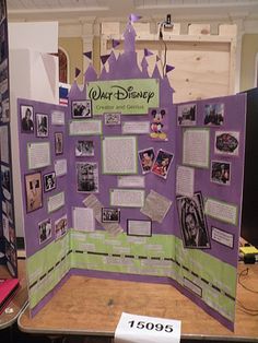 a purple and green display with pictures on it's sides, in the middle of a room