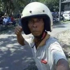 a woman wearing a helmet and holding her fist up