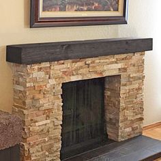 a stone fireplace in the corner of a living room with a painting on the wall