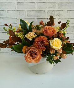 a white vase filled with lots of flowers