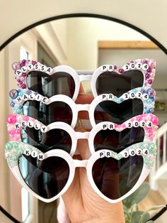 a person holding up some sunglasses with hearts on them