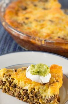 a piece of quiche with sour cream on top and a serving dish in the background