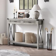 a console table with two lamps and baskets on the bottom shelf in front of it