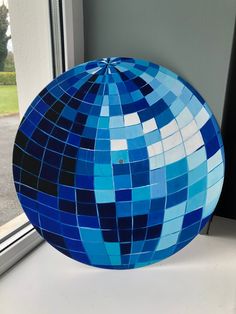 a large blue ball sitting on top of a window sill next to a window